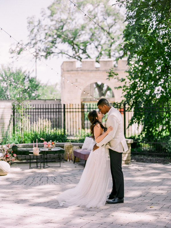 Couple kissing in front of the gates at Upper Fort Garry Provincial Park by Brittany Mahood.